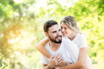 Fototapeta premium Happy young caucasian couple embracing together with passionate love in public park,Couple in love hugging and having romantic tender moments in the summer vacation.Lifestyle loving couple at nature.