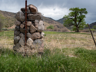 Rock cage fence post using local rocks.