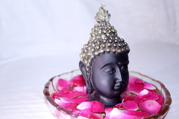 buddha god face among rose petals