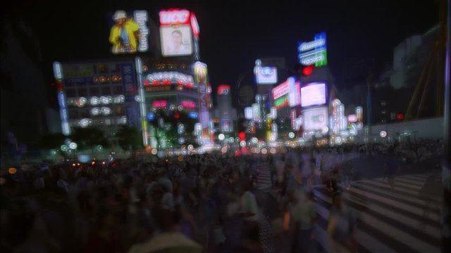timelapse of people crossing the famous shibuya crosswalk in tokyo at night with a light blurr
