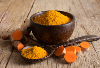Turmeric powder and fresh turmeric (curcumin) on wooden background,For making healthy food.