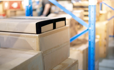 A pile of cardboard box parcel prepare to put on the shelf or blue metal rack