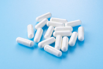 White capsules placed on blue background