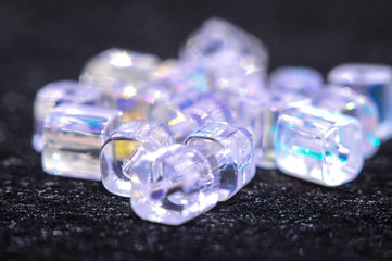 
blue square beads on a black background in low key with a boke in the background