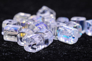 
blue square beads on a black background in low key with a boke in the background