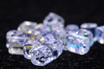
blue square beads on a black background in low key with a boke in the background