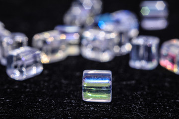 
blue square beads on a black background in low key with a boke in the background