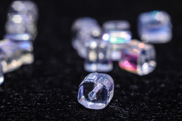 
blue square beads on a black background in low key with a boke in the background