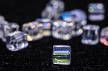 
blue square beads on a black background in low key with a boke in the background