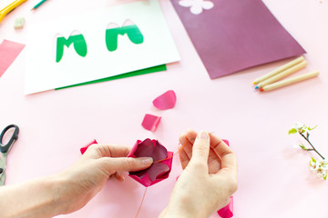 Instruction step 6. DIY greeting card as a gift for mom's day with an applique with a flower made of paper.