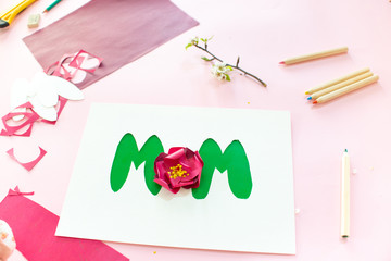 Instruction step 1. DIY greeting card as a gift for mom's day with an applique with a flower made of paper.