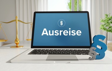 Ausreise – Recht, Gesetz, Internet. Laptop im Büro mit Begriff auf dem Monitor. Paragraf und Waage.