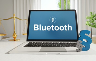 Bluetooth – Recht, Gesetz, Internet. Laptop im Büro mit Begriff auf dem Monitor. Paragraf und Waage.