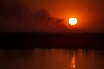 atardecer en el rio con humo