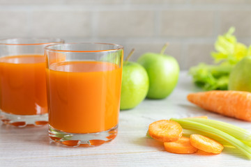 Two glasses with carrot juice, celery and green apple on the table. Diet, healthy eating, food and...