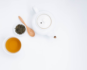 cup with tea and teapot on white background, over light
