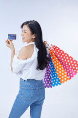 Shopping concept. Overjoyed woman holding credit card and paper bags