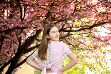 Portrait of a beautiful teenage girl in delicate sakura flowers