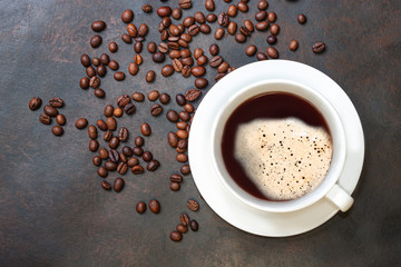 Obraz na płótnie Canvas Coffee cup and coffee beans on dark table.