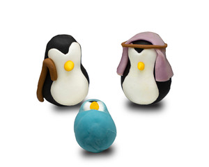 penguin nativity scene Christmas decoration on white background, handmade figurines of Joseph, Mary and Jesus on white background