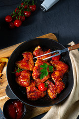 Spicy chicken wings in honey with potato wedges
