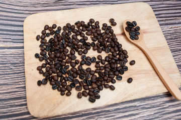 Coffee beans in wooden spoon isolated.