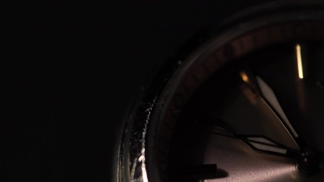 Close up of female watch against black background