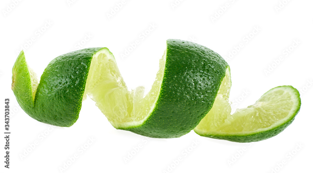 Wall mural lime fruit isolated on a white background. lime cut in shape of a spiral.