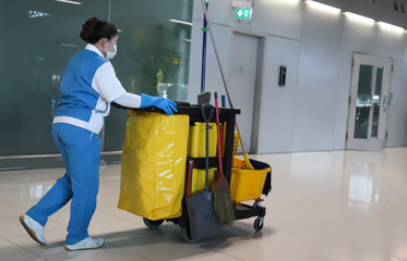Closeup of janitorial, cleaning equipment and tools for floor cleaning and woman woker.