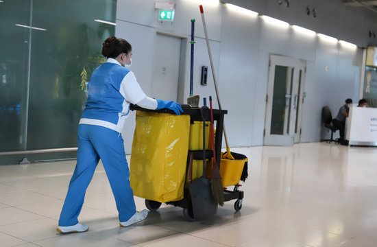Closeup of janitorial, cleaning equipment and tools for floor cleaning and woman worker.