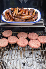 Burgers and sausages on an outdoor garden barbecue