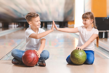 Fototapeta premium Little children playing bowling in club