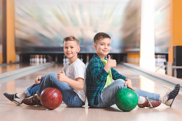 Fototapeta premium Little boys playing bowling in club
