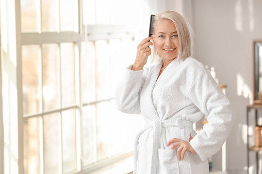 Mature Woman Combing Her Hair In Bathroom