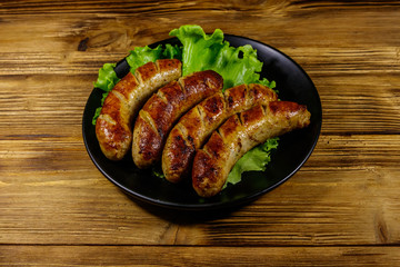 Tasty grilled sausages on a wooden table