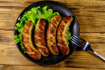 Tasty grilled sausages on a wooden table. Top view