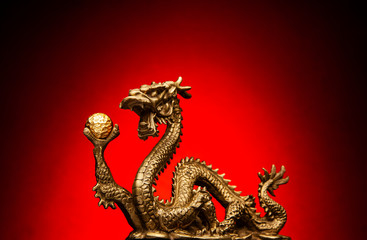 Chinese Dragon holding a gold Sphere and a red background