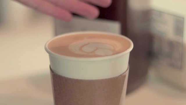 Finishing the perfect latte with a topping of cinnamon.