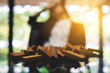 Businesswoman get stressed while having a problem at work in office with wooden blocks of Tumble tower game on table