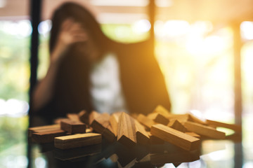 Businesswoman get stressed while having a problem at work in office with wooden blocks of Tumble tower game on table