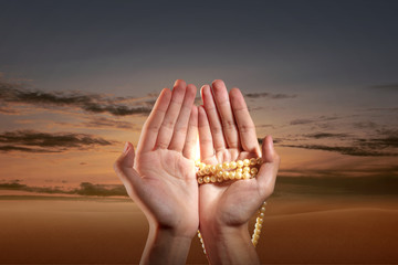 Muslim man praying with prayer beads on his hands
