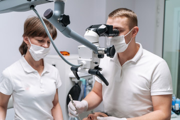The dentist examines the patient's teeth with a dental microscope. Modern medical equipment. Oral treatment concept. Closeup. Selective focus.