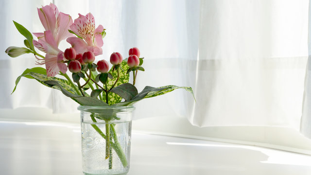 A small spring bouquet. Pink alstroemeria, red hipericum and gold dust dracaena.