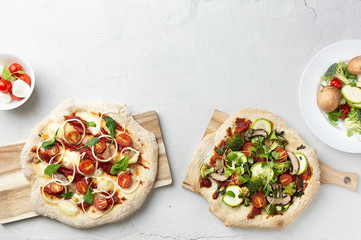 Two types of vegetarian pizza with vegetables on Roman pastry with broccoli, zucchini, tomatoes,...