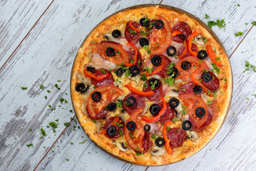 Flat lay photograph of tasty Italian pizza on grey rustic wooden background. Copy space banner.