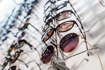 Sunglasses in the shop display shelves. Stand with glasses in the store of optics