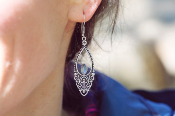 Outdoor detail of female ear wearing beautiful elegant earring