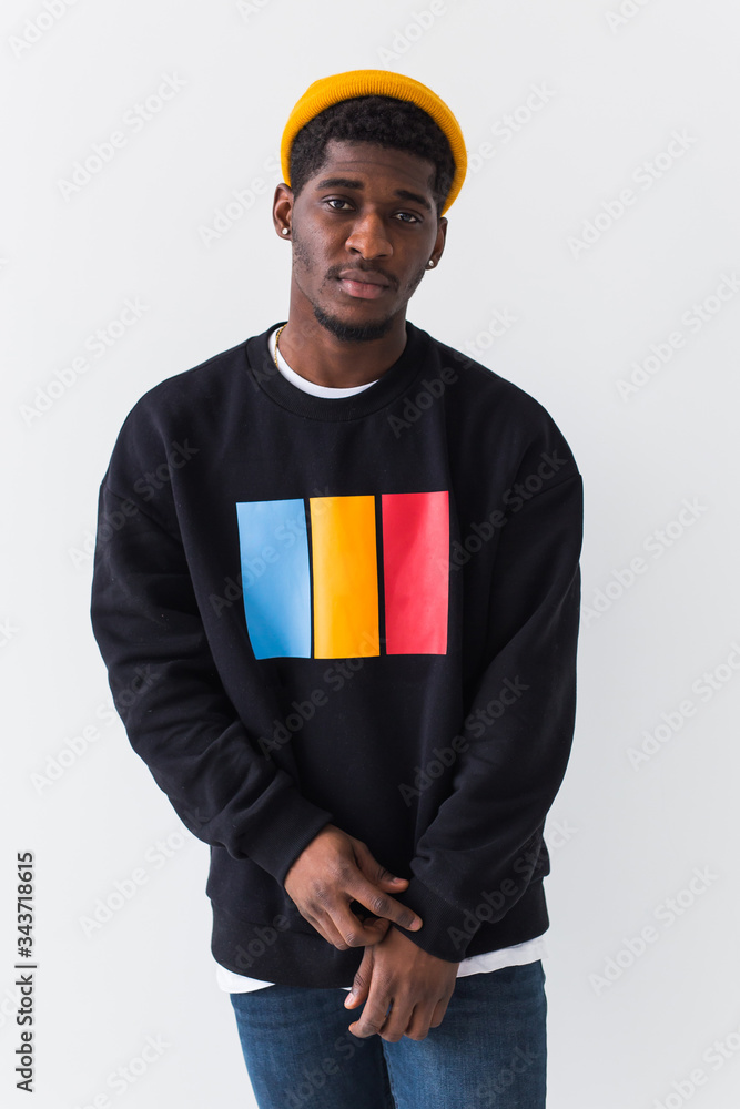 Wall mural youth street fashion concept - portrait of confident sexy black man in stylish sweatshirt on white b - Wall murals