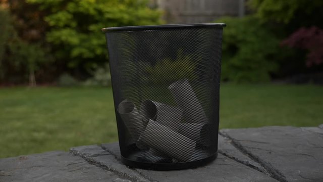 Side view of empty toilet paper rolls randomly emptied into trash can, 180p to 30p slow-motion
