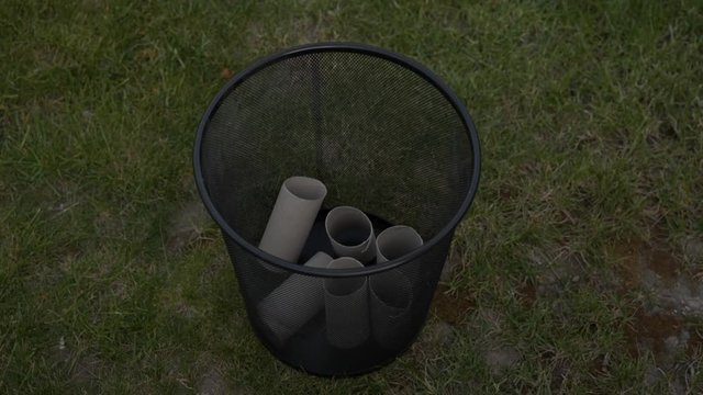 Downward view of empty toilet paper rolls uniformly emptied into trash can, 180p to 30p slow-motion